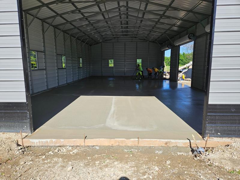 Large concrete floor slab poured inside a steel garage building