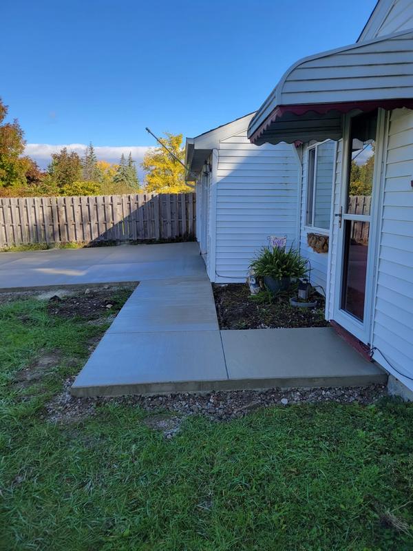 New concrete walkway and patio wrapping around a home