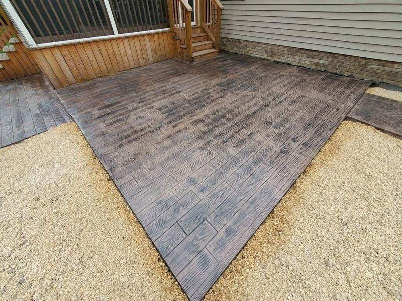 Wood-plank stamped concrete patio stained to look like hardwood decking