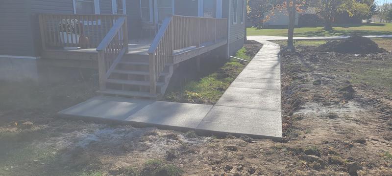 Finished broom-finish concrete walkway and landing at a home's deck steps