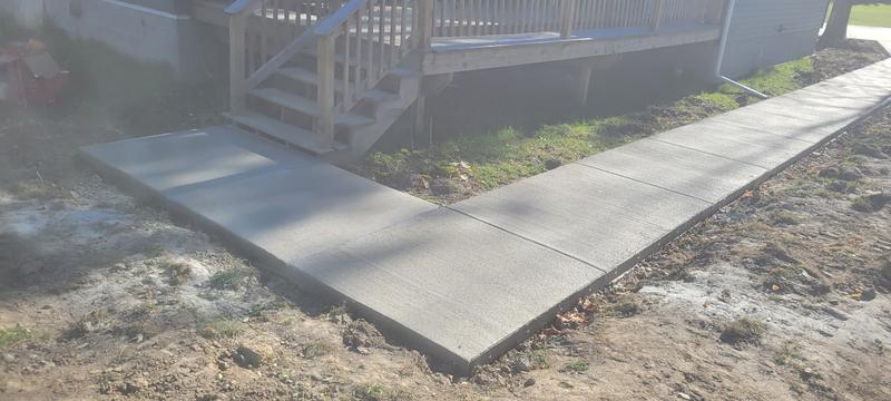 New concrete walkway and step landing poured alongside a home