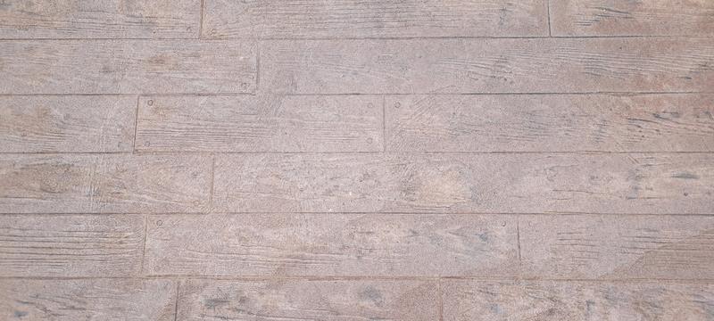 Close-up of the realistic wood-plank texture in stamped concrete