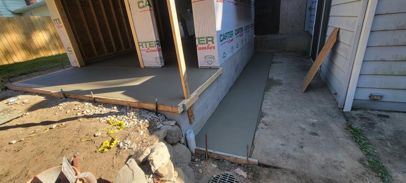 Freshly finished broom-finish concrete patio and walkway at a new home