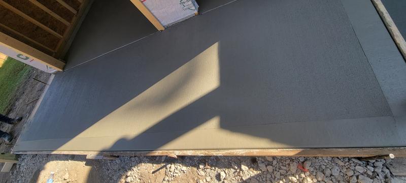 Finished broom-finish concrete walkway beside a home