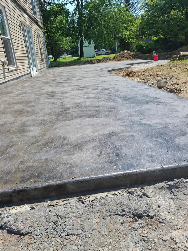 Large finished concrete patio with a smooth colored finish and curved edge