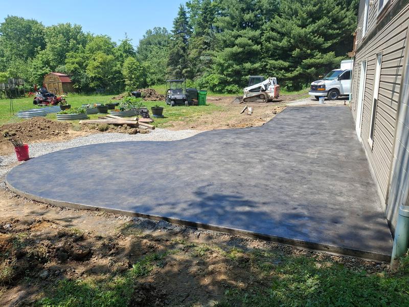 Large curved concrete patio finished behind a home in Northeast Ohio