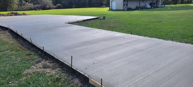 Wide concrete driveway and parking pad poured near a pole barn